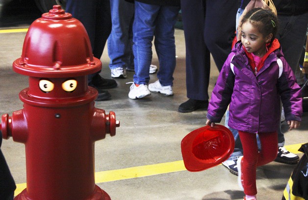 Inquisitive 3-year-old Netsanet Bolser meets “Pluggie” the fire hydrant robot