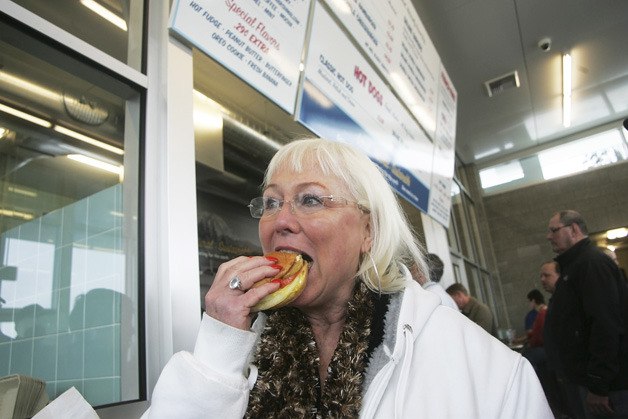 Kelly Rotroff of Auburn enjoys her burger as the first customer at Pick-Quick Drive In No. 2. The family-run eatery officially opened its doors Tuesday to a large crowd.