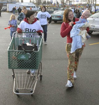 Big Give volunteer Noreen Summers pushes a cart of Thanksgiving food for Kara Day and her son Jeffrey