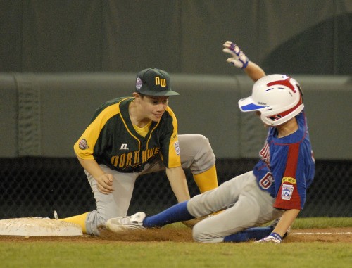 Dylan Davis comes up short of a tag at third base as Midwest’s Lucas Wencl advances. The play was called an out but reversed after it was reviewed on instant replay. This is the first year instant replay has been used at the Little League World Series.