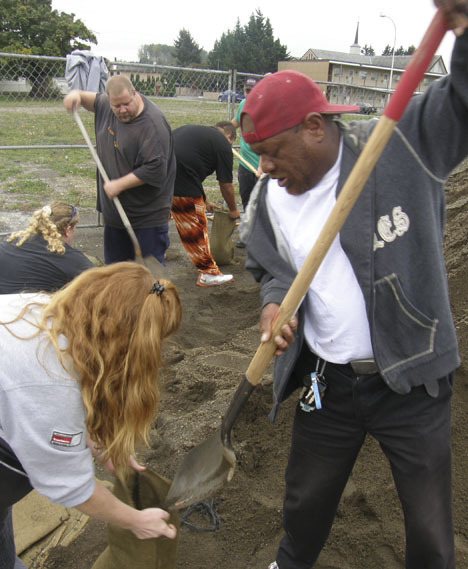 Workers from the Auburn Food Bank pack sandbags at Les Gove Park. The food bank