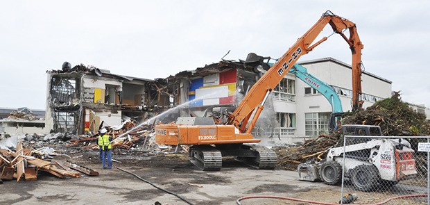 Crews knock down the main building of the old Auburn High School on Tuesday afternoon. The debris is being removed to make way for parking for the new high school along East Main Street