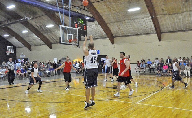 Auburn Police’s Luke Goethals fires a shot during the benefit game at the Auburn Adventist Academy gym.