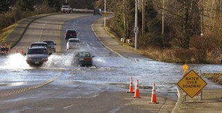 Heavy rains and melting snow have caused  local flooding. Motorists try to negotiate through some floodwaters on 37th Street in Auburn.