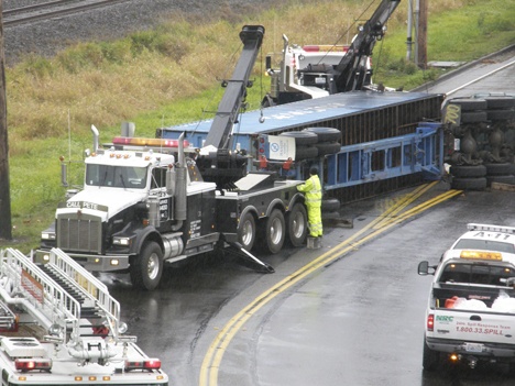 Crews try to upright and remove a truck that blocks C Street Northwest on Monday morning. Two tractor trailer trucks collided at the 1400 block of the street