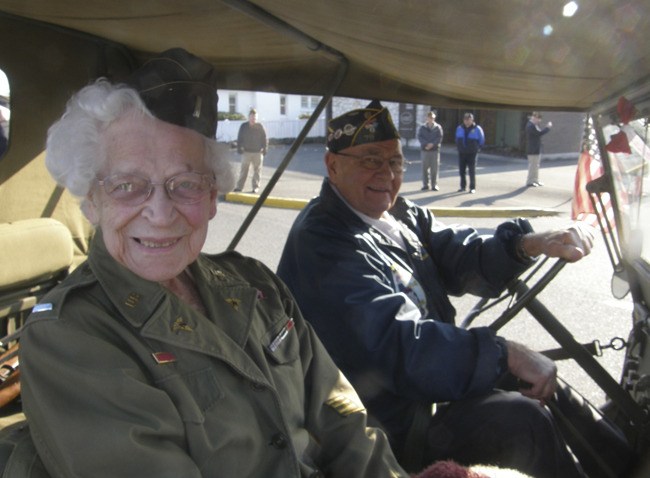 World War II veteran Annie McDonald catches a ride in an antique jeep during the Veterans Day Parade.