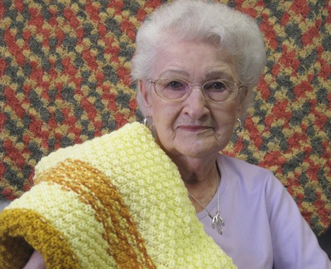 Hazel Brown displays some of the lap robes she and her friends knitted for wounded soldiers. The Touch of Home group was honored for its work.