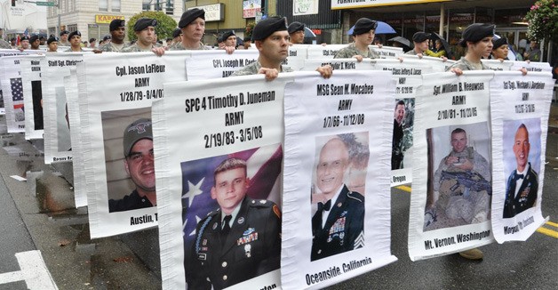 Soldiers from the 80th Ordnance Battalion at Lewis-McChord carry banners of fallen military men and women from the Iraq and Afghanistan wars. The Fallen Heroes Banner Project was coordinated by Spokane mother Kim Cole to remember the soldiers from Washington