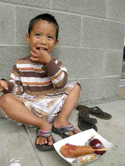 Junilla Akeang tucks into a free lunch provided by the Auburn School District Monday at Auburn's Veterans' Park.