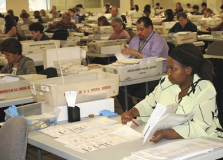 Election worker Regina Ngoya on Tuesday inspects ballots for such issues as voter-corrected errors before the ballots are sent on for counting.