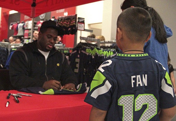 Seahawks defensive tackle Brandon Mebane obliges a young fan by signing a jersey this past Tuesday at the Auburn Sports Authority.