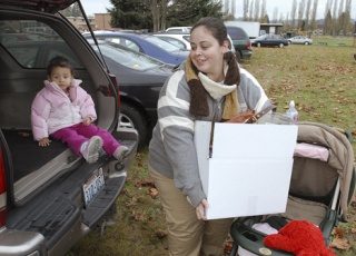 Terri Cook loads her holiday food basket into the back of her vehicle as her daughter Amarah