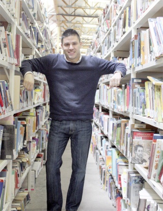 Hector Rivas stands amidst the Thrift Books warehouse