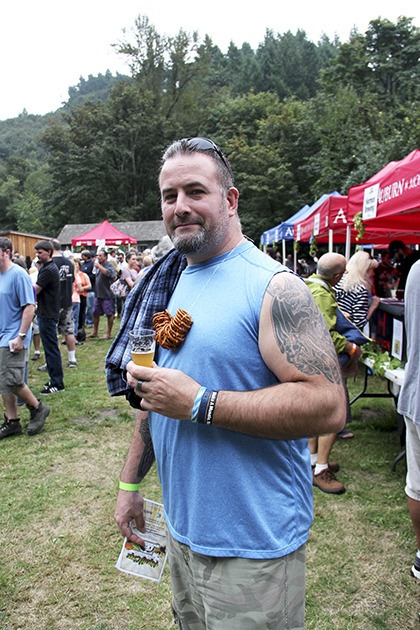 Mark Temple of Puyallup enjoys a beer with a pretzel snack necklace at last year's Hops and Crops Brew Festival at Mary Olson farm.