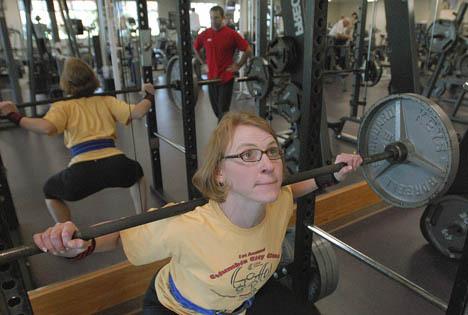 Jill Joiner-Wong practices squats at the Auburn Valley YMCA under the watch of her trainer