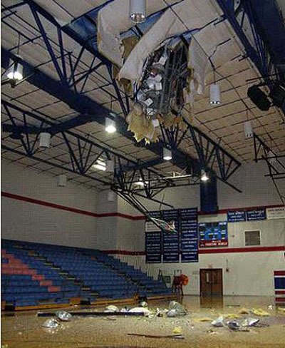 A Whitco Company LP light pole sticks through the roof of a gymnasium at Hays High School in Buda