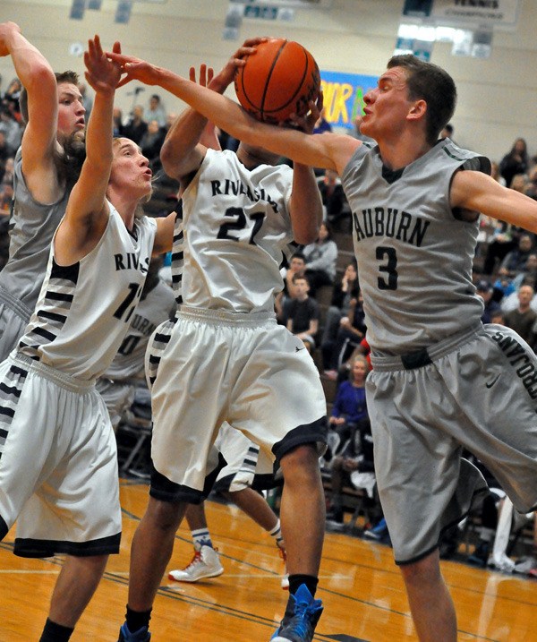 Auburn Riverside's Kolten Rosin (21) and Julian Gulchuk (3) battle Auburn's Tyler Peray for the ball (3).