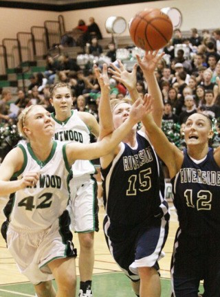 Auburn Riverside's Kara Jenkins (15) and Amanda Thompson (12) battle Kentwood's Courtney Johnson (42) and Liz Mills (25) for the ball during a recent SPSL North game. Kentwood went on to win the mid-December showdown