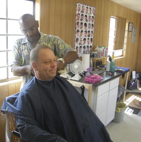 Artemas Malone gives regular Patrick Emmons a trim in a makeshift shop
