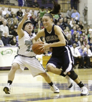 Auburn Riverside's Amanda Thomas drives by Kentwood's Kylie Huerta in the West Central District title game.