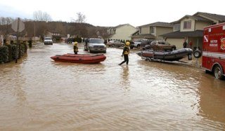Auburn water rescue personnel responded to flooded city streets in Pacific. Residents are trying to mop up from floodwaters that seeped into the area late Thursday