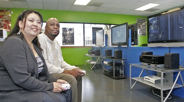Gamebreakerz owners Donghee and Shandor Collins play the new  ‘Halo Reach’ on separate TVs at their new Auburn location. Gamebreakerz offers kids a place to try out games.