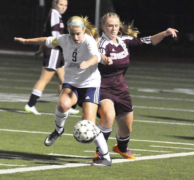 The Ravens’ Izzy Creighton tries to dribble the ball past an Enumclaw defender during SPSL 3A soccer action Tuesday night.