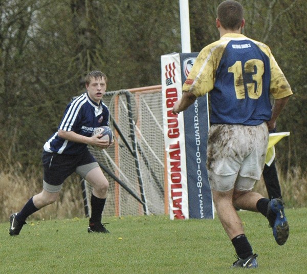 Calum Ramsay advances the ball against an opposing player during a Rainier Plateau Junior Rugby match.