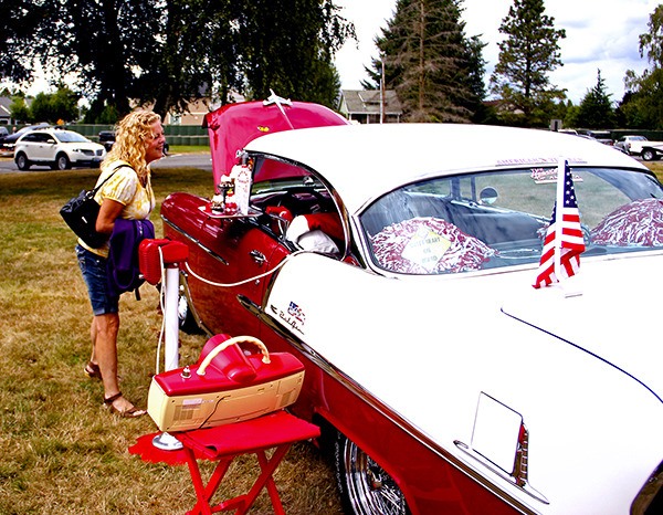 Lacie Parrino of Bonney Lake checks out Stan and Pam Pauley’s 1955 Chevrolet Bel Air at the Terry Home Show and Shine in Pacific City Park.