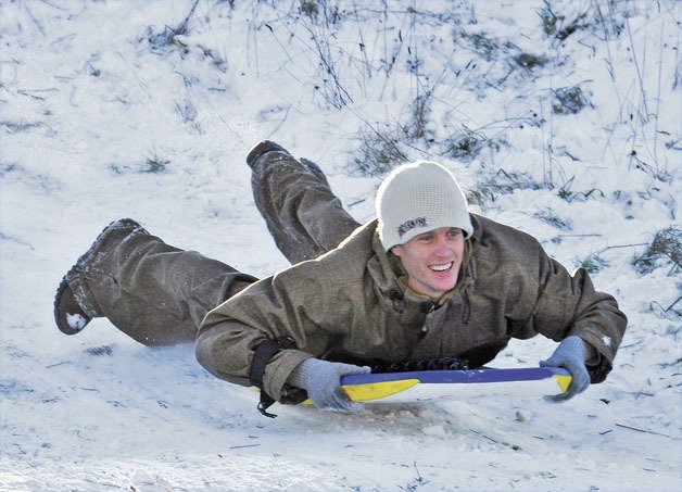 Patrick Clifford slides down a snowy hillside at the Auburn Adventist Academy Field on Tuesday.
