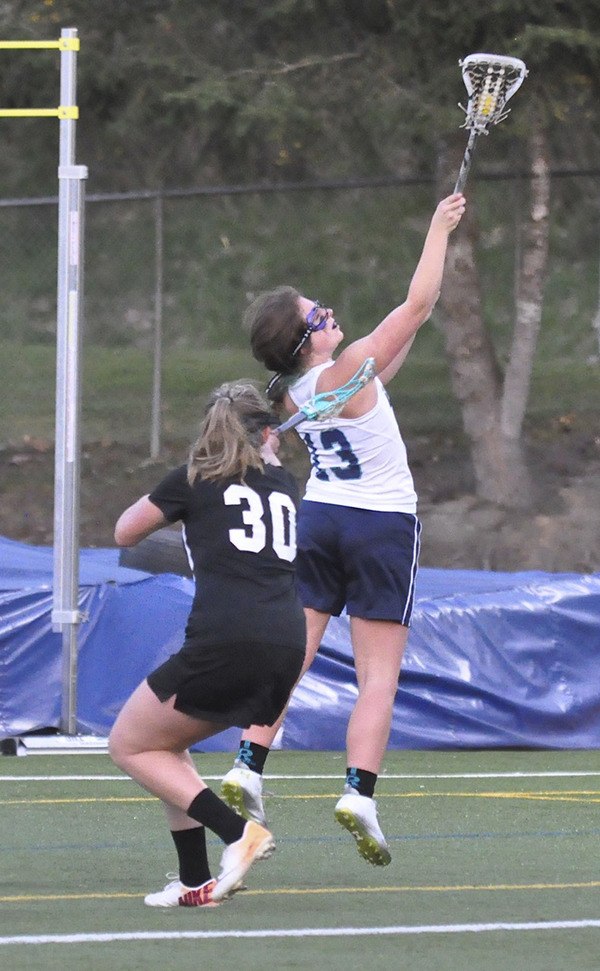 Auburn Riverside's Maddie Lancaster (13) takes to the air to corral a pass.