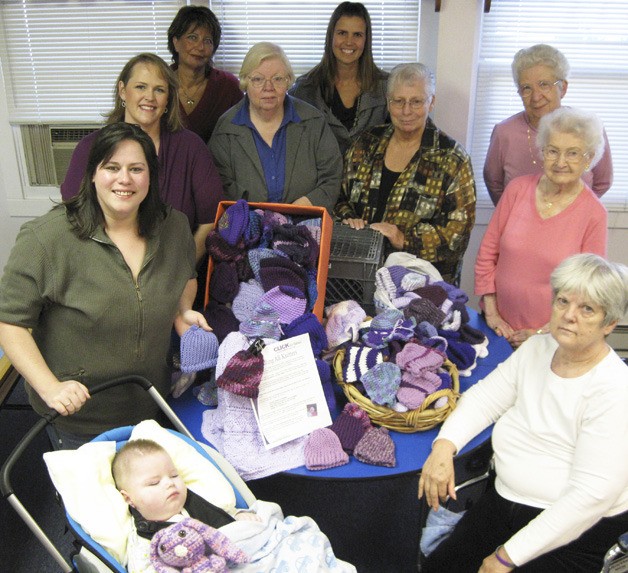 Devoted knitters and crocheters from the Pacific Community Center gathered last week to donate  240 purple caps to the Click for Babies campaign. Jamie Thompson