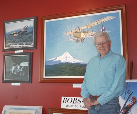 Auburn artist Robert Parks poses in front of some of his artwork on display at the Fields and Company restaurant downtown at the Sound Transit Plaza.