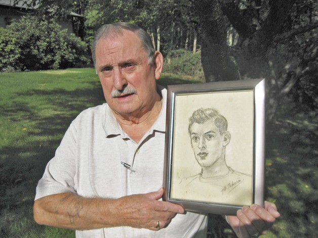 Larry Doll holds a sketch of himself as a young GI who survived the early days of the Korean War more than 60 years ago.