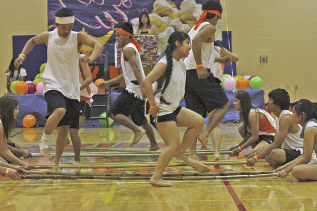 A group of students representing the Philippines performs a tinikling dance with bamboo poles at Auburn Mountainview's multicultural fair.