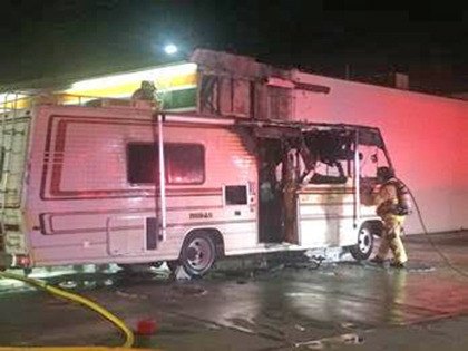 VRFA firefighters sift through a fire-damaged motorhome Wednesday night.