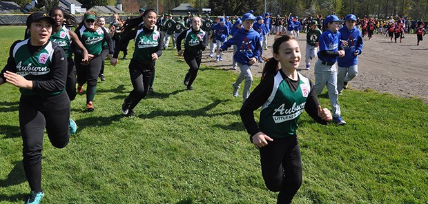 Teams charge out to the field during Auburn Little League opening ceremonies at Brannan Park last Saturday.