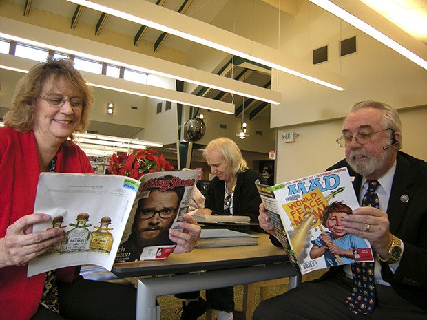 Pacific Mayor Leanne Guier and Algona Mayor Dave Hill peruse periodicals at the Algona-Pacific Library.