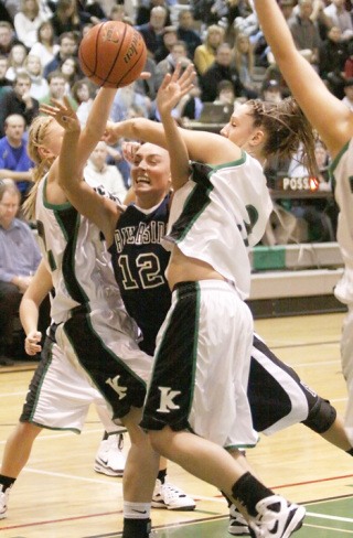 Auburn Riverside's Amanda Thomson is hammered by Kentwood defenders as she drives the lane.