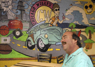 Auburn’s Mike Jasper sits in front of a mural that adorns the interior of his new restaurant