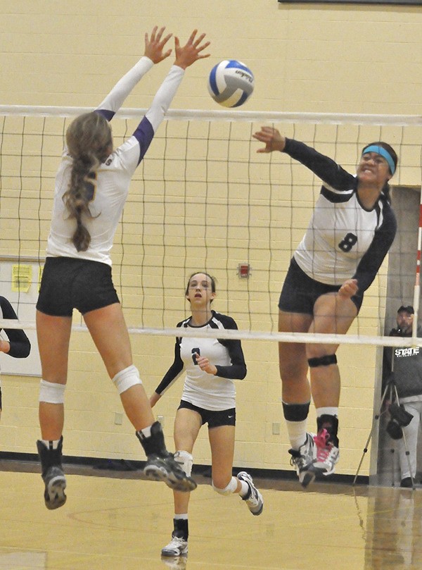 Auburn Riverside's Precious Atafua (8) powers one over the net while teammate Calley Heilborn (2) looks on. Both girls were named to the SPSL 3A All-League team.