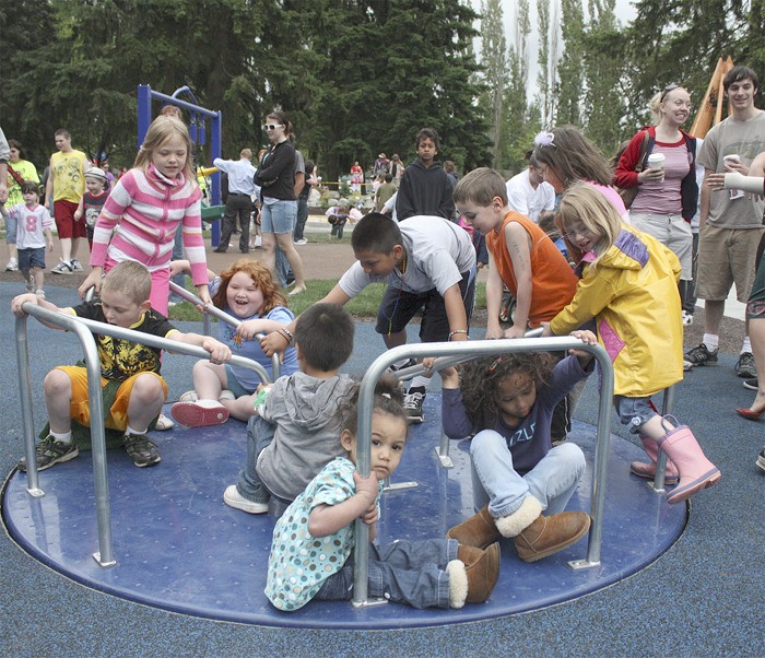 Children take a turn on the Discovery Park merry-go-round. The city opened the park this past Friday.