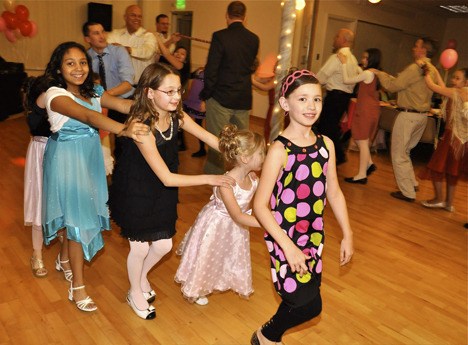 Daughters and fathers do the catapiller move around the Senior Activity Center during last weekend's fourth annual Daddy Daughter Date Night. The event was put on by the Auburn Park