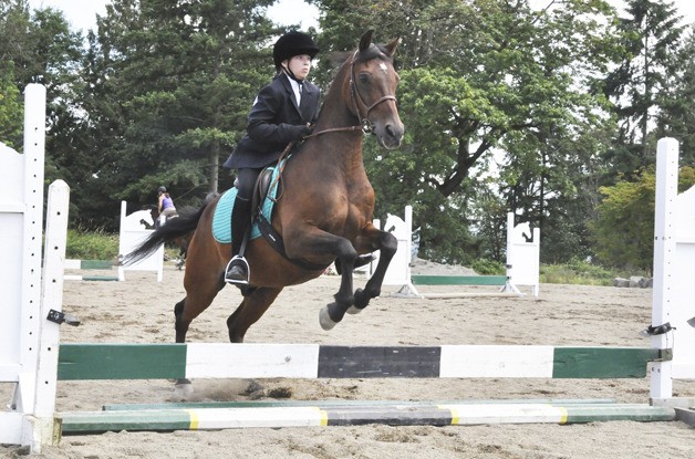 Anna Phillips guides Bo over a jump during the Save a Forgotten Equine’s fifth annual Benefit Horse Show.