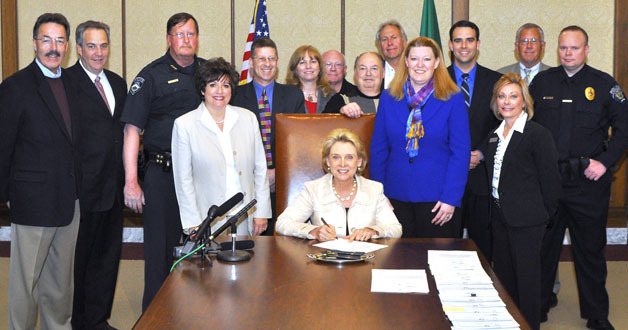 Rep. Katrina Asay (center right) and Sen. Tracey Eide (center left) stand alongside a sitting Gov. Christine Gregoire