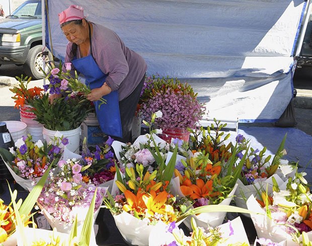 See Her prepares flowers for sale at the Auburn International Farmers Market last year.
