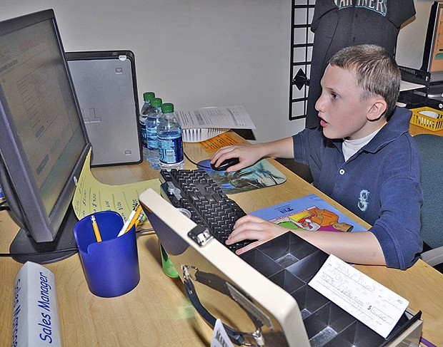 Alex Paulson learns how to manage the Mariners Store at Junior Achievement World.