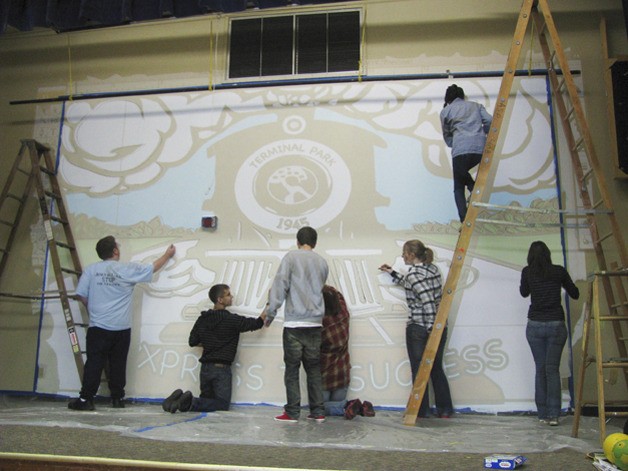 Auburn High School students go to work on a mural to beautify Auburn's Terminal Park Elementary.