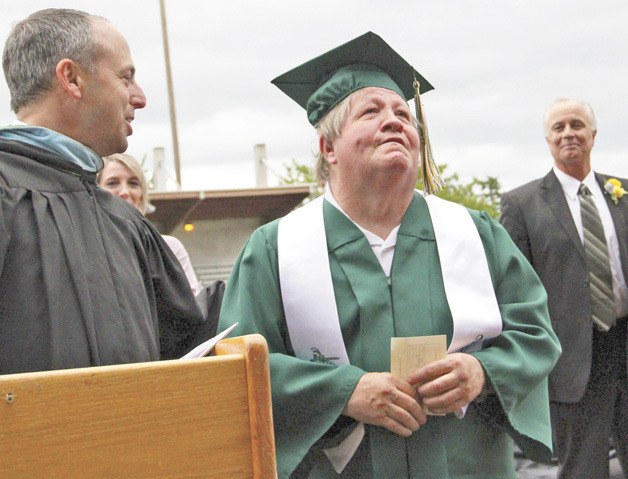 Bobby Vogel soaks in the adulation of the crowd after receiving an honorary degree at the Auburn High School graduation ceremony last Sunday. At left is Principal Richard Zimmerman