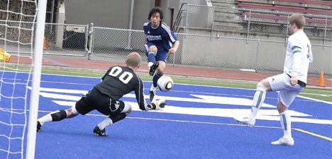 Auburn Riverside forward Hansol Park tries to get one by Kentwood's goalkeeper Rodney Greiling at French Field.